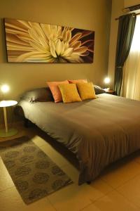 a bedroom with a large bed with yellow and orange pillows at Lagoon Marina Apartments in Koolbaai