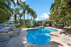 uma piscina com um banco e uma casa em Shell House em Anna Maria