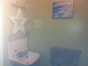 a bathroom with a sink and stars on the wall at Abel's Harp in Bromlow