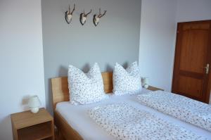 a bedroom with a bed with white sheets and pillows at Ferienhaus Mätzler in Schwarzenberg