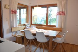 a dining room table with white chairs and a window at Ferienhaus Mätzler in Schwarzenberg