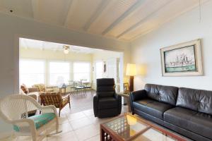 a living room with a black leather couch and chairs at Grant's View in Anna Maria