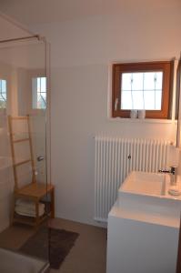 a bathroom with a sink and a window and a chair at Ferienhaus Mätzler in Schwarzenberg +43 photos