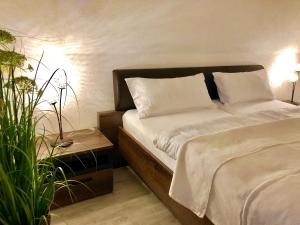 ein Bett mit weißer Bettwäsche und Kissen in einem Schlafzimmer in der Unterkunft Hubertusnest in Bad Berka