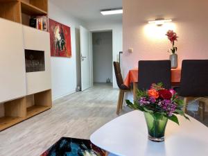 ein Wohnzimmer mit einem Tisch und einer Blumenvase in der Unterkunft Hubertusnest in Bad Berka