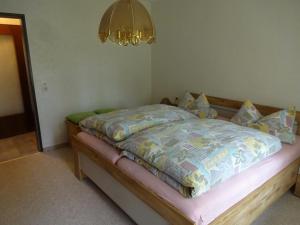 a bed with a quilt on it in a room at Ferienwohnung Kurparkblick in Hohegeiß