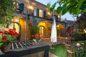 an outdoor patio with a table and an umbrella at Wine Resort Villagrande in Milo