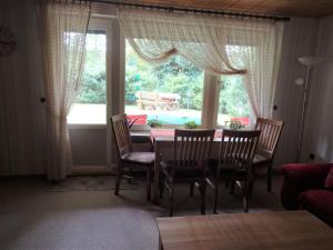 a dining room with a table and chairs and a window at Ferienwohnung Kurparkblick in Hohegeiß