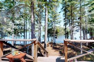 una terraza de madera con mesa y vistas al lago en Sandbar Cabin, en Rockwood 13 fotos más