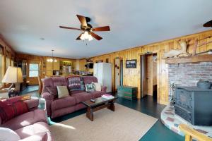 sala de estar con sofá y ventilador de techo en Lower Wilson Pond Refuge, en The Highlands