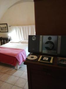 レッチェにあるCasa dei Carrettiのベッドルーム1室(ベッド1台、カウンター内のテレビ付)