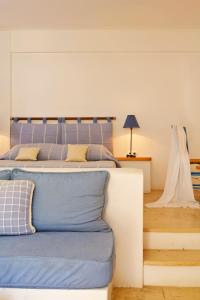 a bedroom with a large bed with a blue bedspread at Tamarix Del Mar Suites in Kamari
