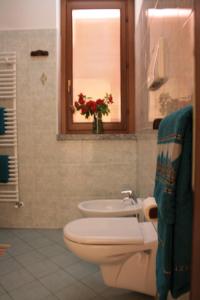 baño con aseo y lavabo y ventana en La Corte Albergo, en Desio