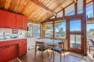 a kitchen with red cabinets and a table and chairs at Rocks Cabin in Copalis Beach