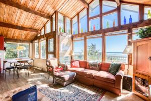 a living room with a couch and some windows at Rocks Cabin in Copalis Beach
