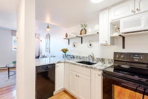 a kitchen with white cabinets and black appliances at All New Historic Charmer in the Heart of Durango in Durango