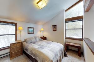 1 dormitorio con 1 cama y 2 ventanas en Meadows Condo Unit #16, en McCall