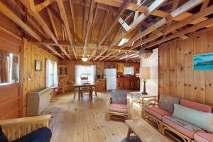 sala de estar con paredes revestidas de madera y cocina en Moosehead Memories, en Rockwood