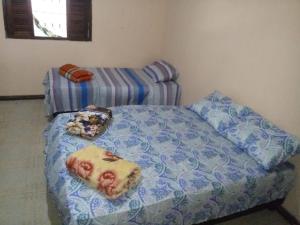 a bedroom with a bed and a couch with pillows at Sitio Santo Antonio HOSTEL in Ilhéus