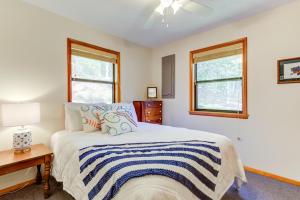 a bedroom with a bed and a desk and two windows at Moss Creek Cabin in Morganton