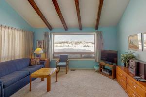 a living room with a blue couch and a tv at Aspenwood 4229-30 in Pagosa Springs
