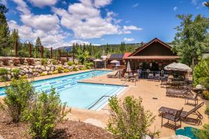a pool at a resort with tables and chairs at Boulders Hideout in Truckee