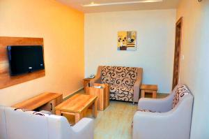 a living room with two chairs and a flat screen tv at Lit Suites in Abuja