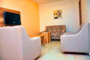 a living room with two chairs and a flat screen tv at Lit Suites in Abuja