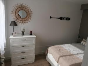ein Schlafzimmer mit einer weißen Kommode und einem Spiegel in der Unterkunft Le Voltaire-Sleep in Normandie in Saint Lo