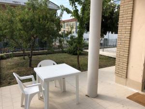 un tavolo bianco e 2 sedie bianche su un patio di Home di Federico a Chivasso