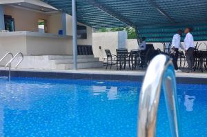 a group of men standing next to a swimming pool at Lit Suites in Abuja