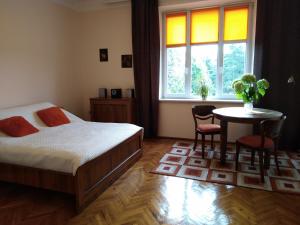 sypialnia z łóżkiem, stołem i oknem w obiekcie Studio Krakowski Styl w Krakowie