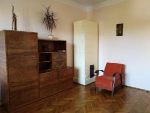 克拉科夫的住宿－Studio Krakowski Styl，客厅配有红色椅子和橱柜