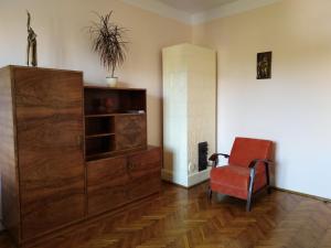 salon z czerwonym krzesłem i szafką w obiekcie Studio Krakowski Styl w Krakowie