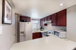 a kitchen with a white refrigerator and wooden cabinets at Aspenwood 4262 in Pagosa Springs