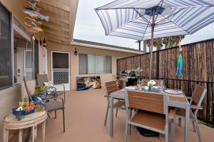 a patio with a table and chairs and an umbrella at Hideaway Unit C in San Clemente