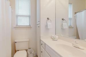 a bathroom with a toilet and a sink and a mirror at Destiny Beach Villa in Destin