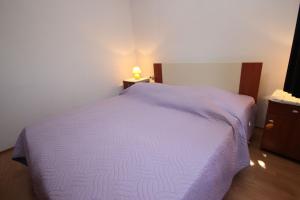 sypialnia z fioletowym łóżkiem i szafką nocną w obiekcie Apartments Saša - pets friendly! w Poreču