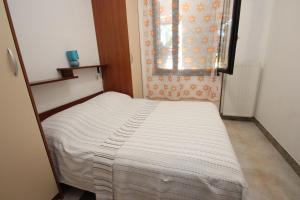 łóżko w małym pokoju z oknem w obiekcie Apartments Saša - pets friendly! w Poreču