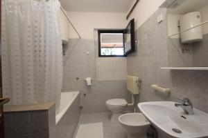 łazienka z umywalką, toaletą i wanną w obiekcie Apartments Saša - pets friendly! w Poreču