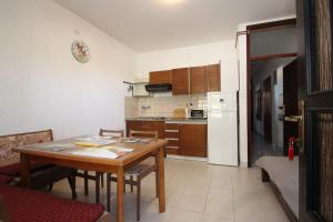 kuchnia ze stołem oraz kuchnia z lodówką w obiekcie Apartments Saša - pets friendly! w Poreču