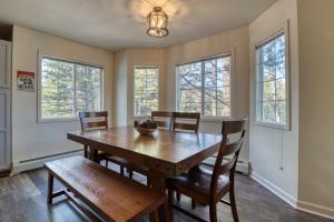 a dining room with a table and chairs and windows at Quiet in the Pines - Permit #3120 in Estes Park