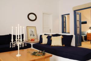 a living room with a blue couch and a table at Tamarix Del Mar Suites in Kamari