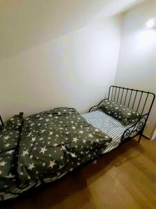 Bett in einem Zimmer mit einer schwarzen Tagesdecke mit Sternen in der Unterkunft Kaszubskie Poddasze in Gołubie