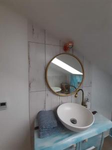 W łazience znajduje się umywalka i lustro. w obiekcie Kaszubskie Poddasze w mieście Gołubie