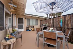 a patio with a table and chairs and an umbrella at Hideaway Unit B in San Clemente