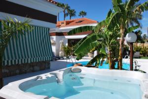 a jacuzzi tub in the backyard of a house at Lacy Golf Apartments in Maspalomas