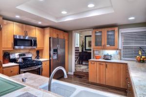 uma cozinha com armários de madeira e um frigorífico de aço inoxidável em North Beach B em San Clemente