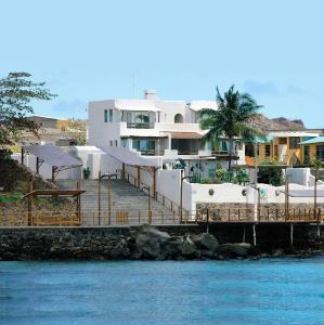 ein Gebäude mit einem Dock neben dem Wasser in der Unterkunft Casa Opuntia in Puerto Baquerizo Moreno