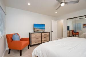 a bedroom with a bed and a chair and a mirror at Villa Del Mar in San Clemente